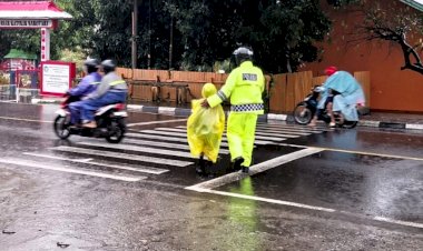 Basah-Demi-Keselamatan,-Satlantas-Polres-Flotim-Bantu-Anak-Menyeberang-Meski-Diguyur-Hujan